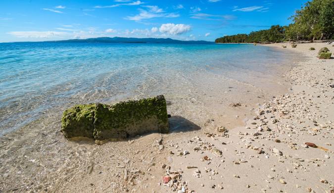 Pesona Pantai Sunyi dengan Laut Tenang dan Langit Cerah yang Menenangkan Jiwa